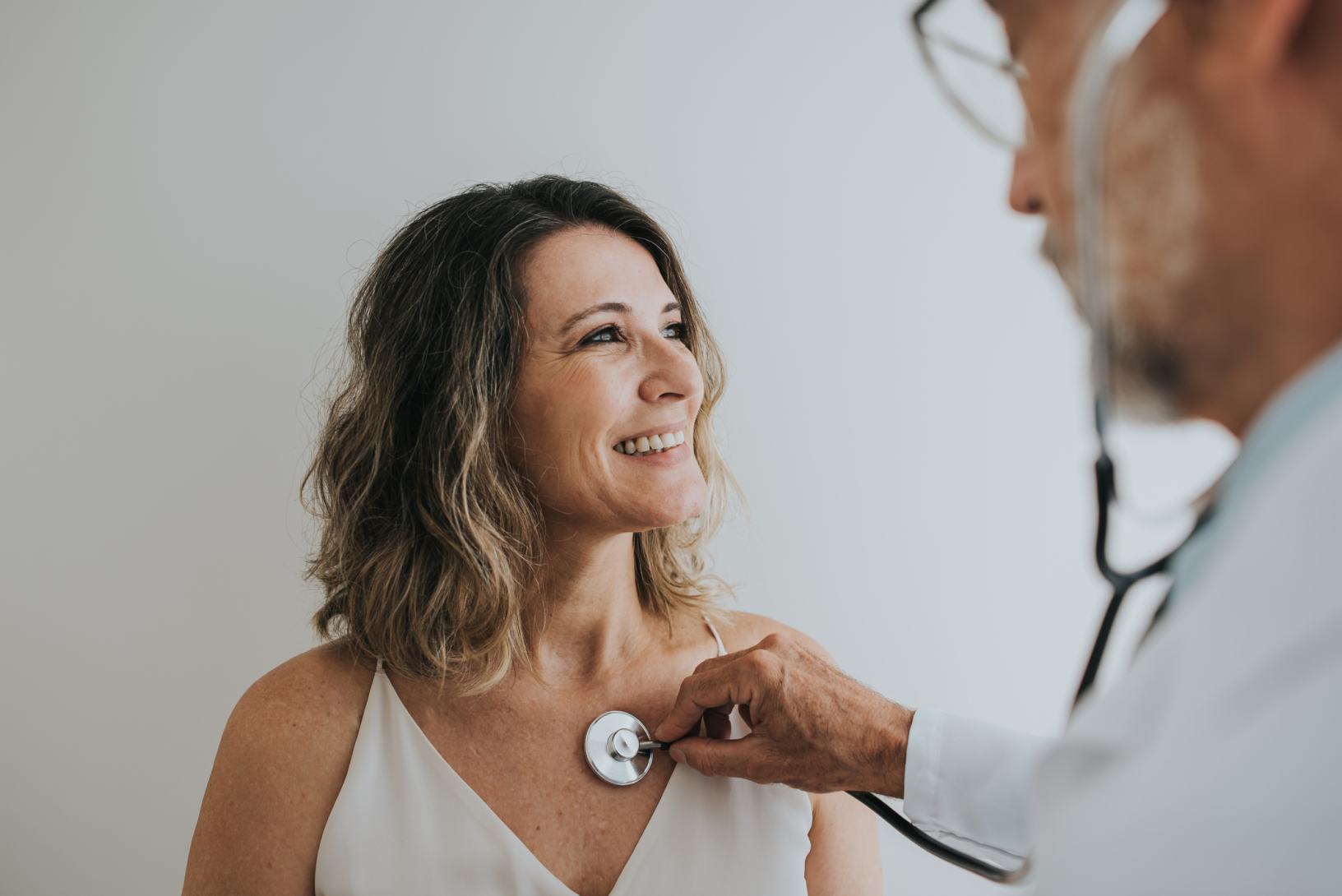 medico visita una donna ascoltando il battito
