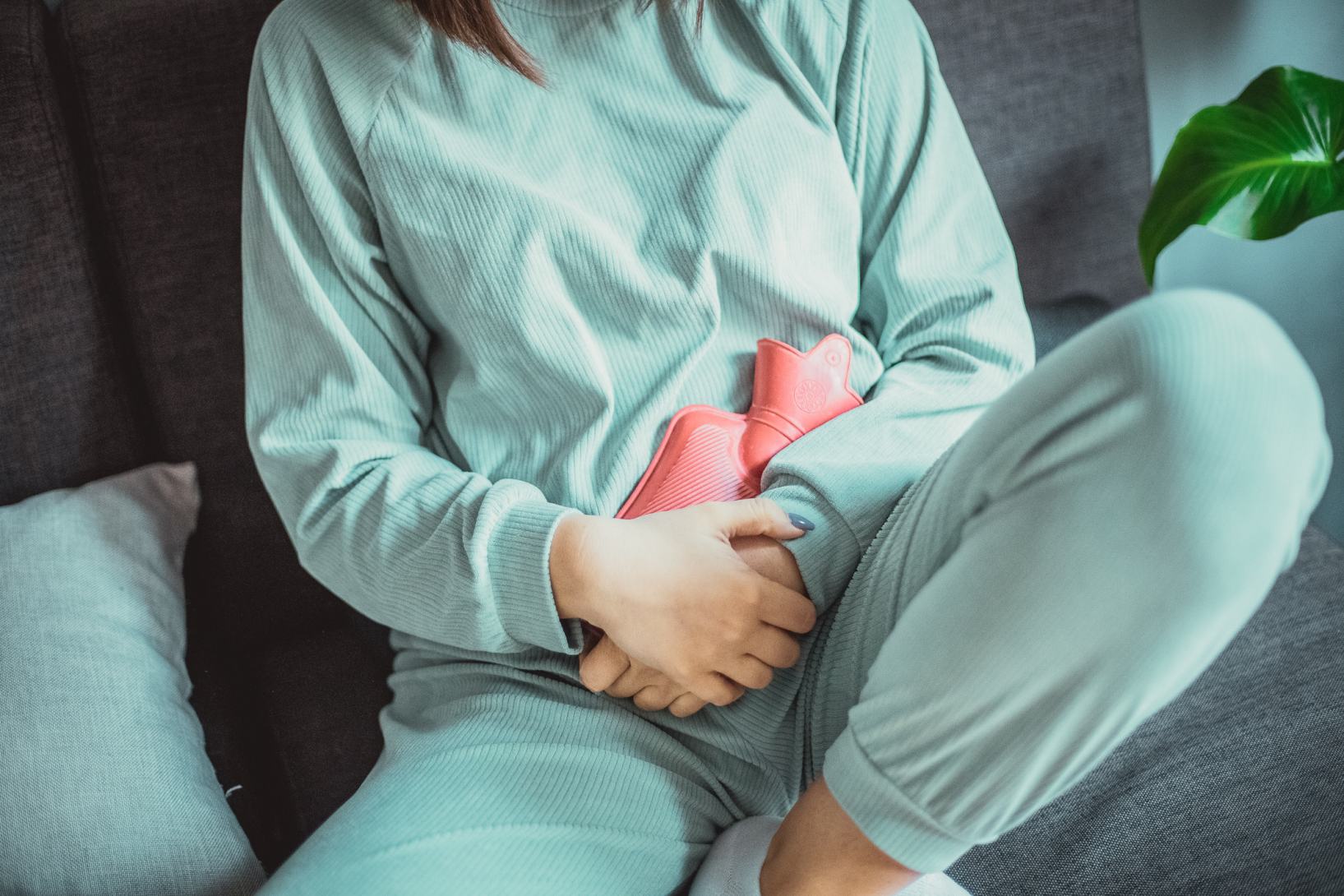 ragazza con ciclo tiene borsa con acqua calda